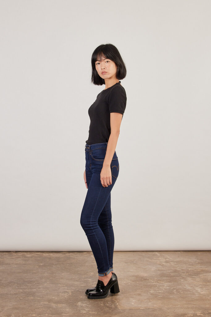 photo avec Delphine, elle porte un t-shirt moulant noir et un jean slim bleu foncé.